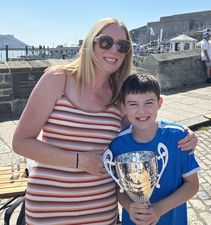 Sarah with Max holding a football trophy